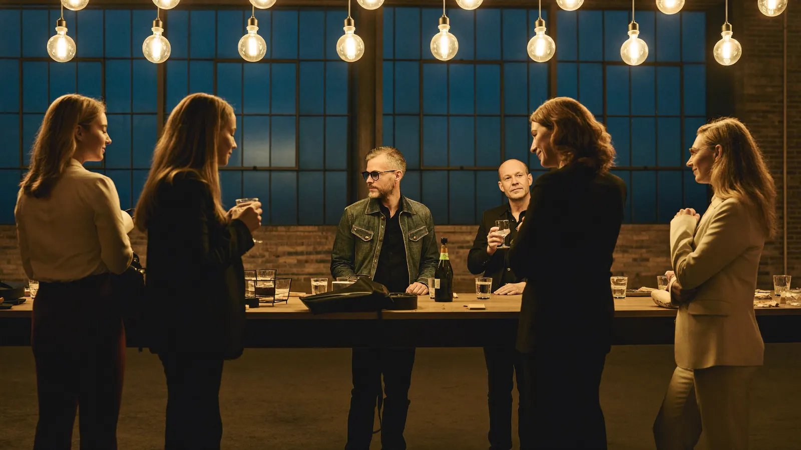 People talking in groups at a bar after an event