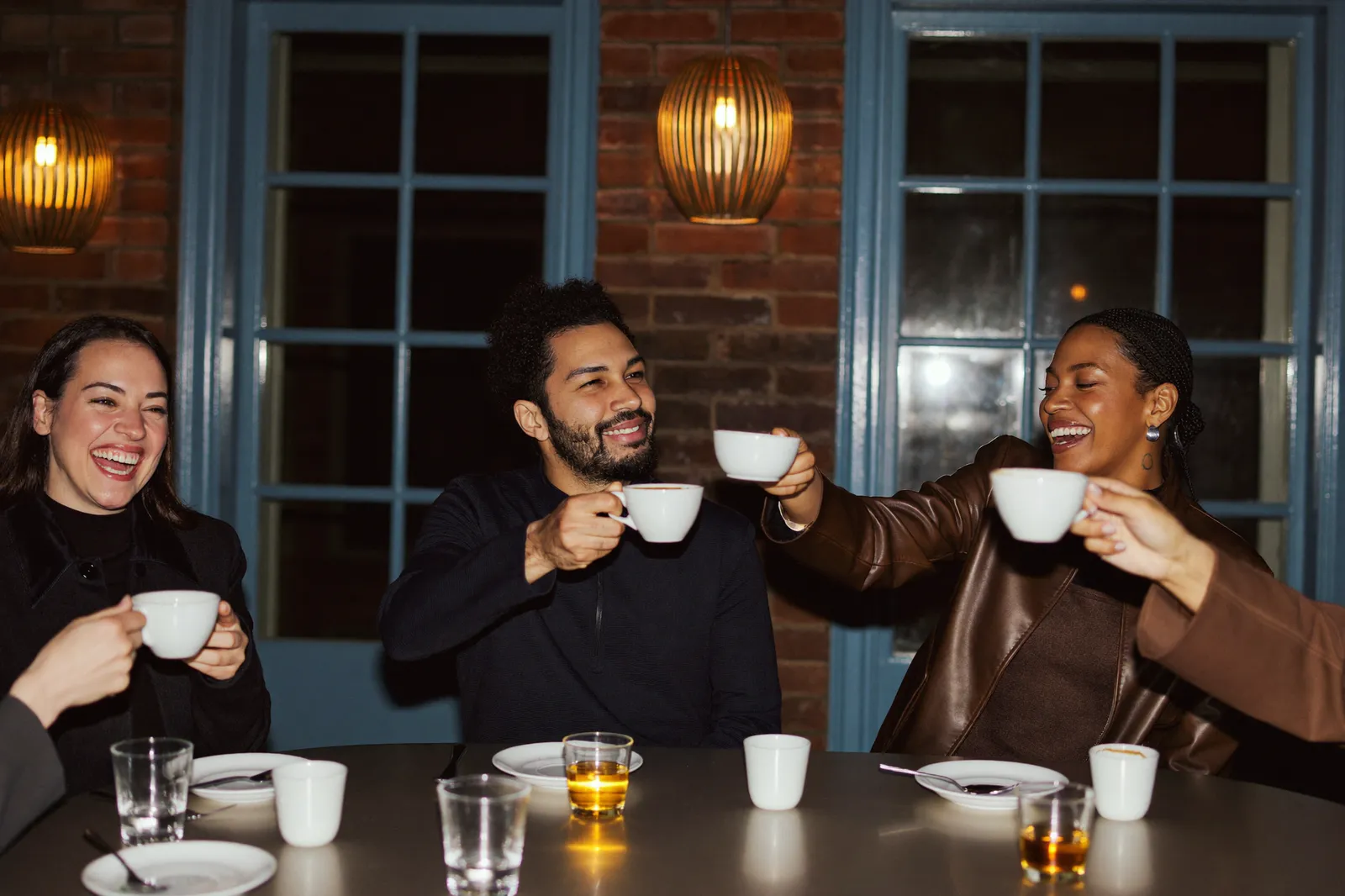 Three business owners raising cups together after an event