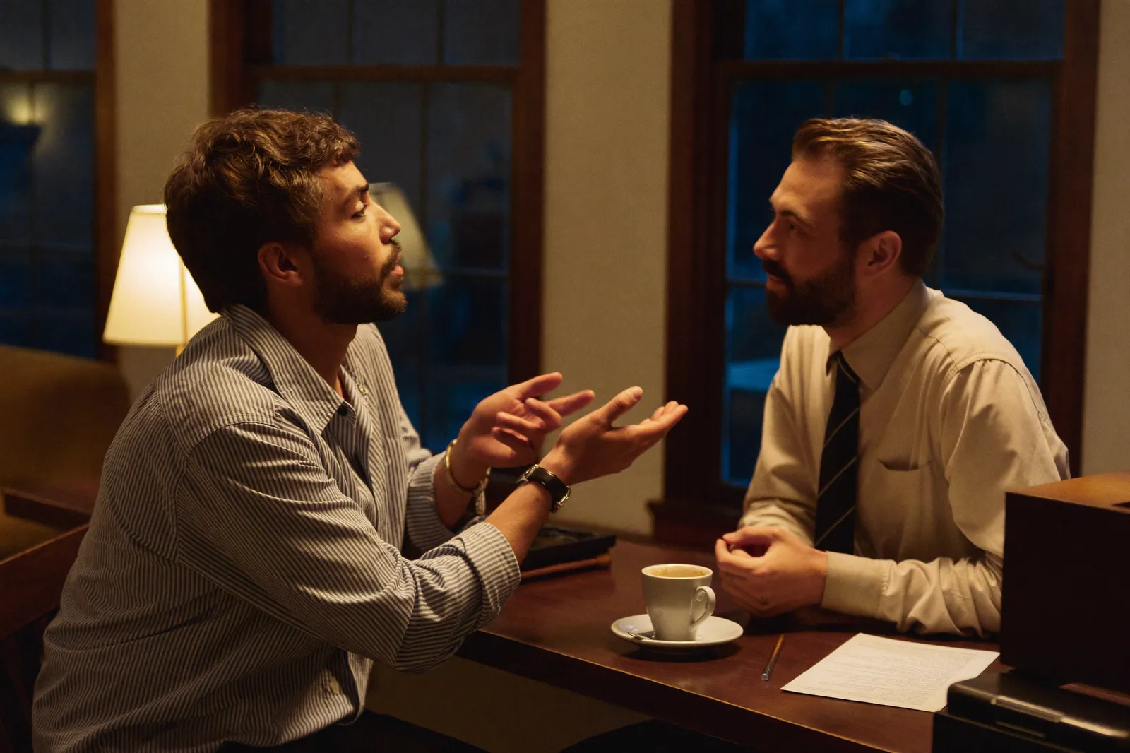 Two founders talking intently across a table in the evening